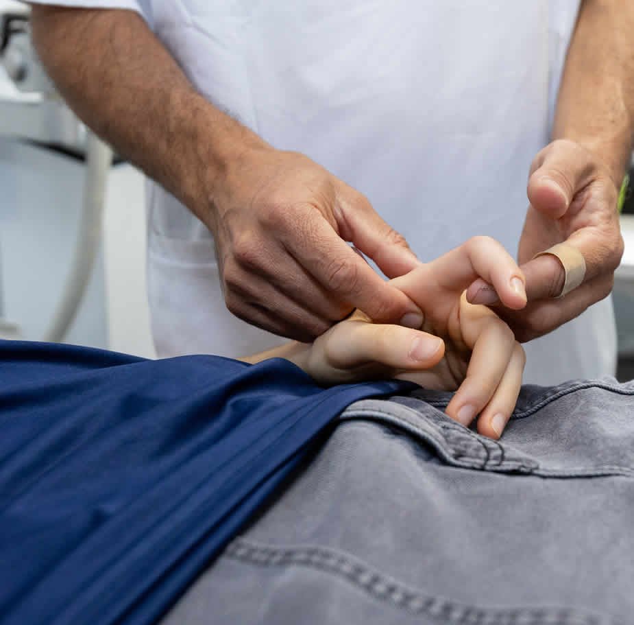 FISIOTERAPEUTA TRATANDO DEDO INDICE DE UNA PACIENTE